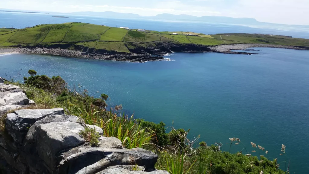Headland with sandy beach and calm blue sea.