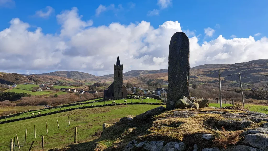 Standing stone with church in the background.