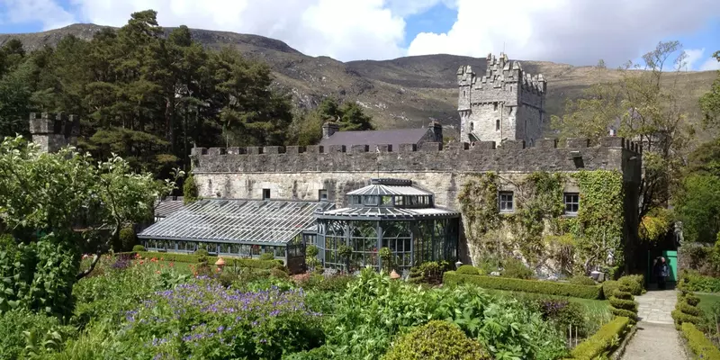 Castle surrounded by green shrubs and trees.