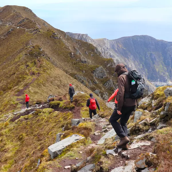 Group of Hikers walking along rough mountain ridge
