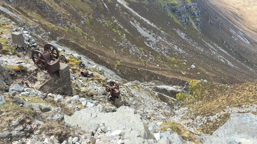 Rusting machineary on rocky mountain side.